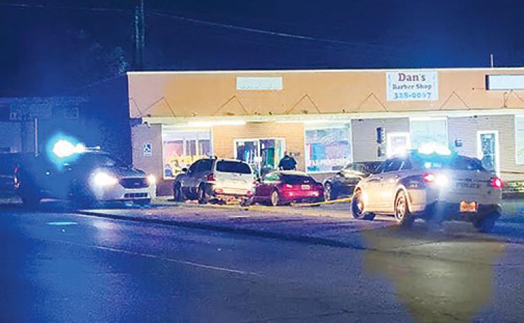 Palatka Police Department vehicles are parked outside of Gold Rush internet café Tuesday night after an employee was robbed and gunfire was exchanged.