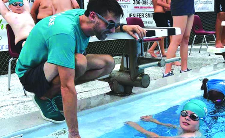 Putnam Sharks swim coach Jacob MacGibbon gives encouragement to swimmer Andrew Coleman during Tuesday’s meet at the Putnam Aquatic Center. (Putnam Sharks Swimming)