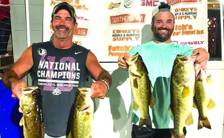 Tom and Tanner Tipton hold their winning fish in the final Corky Bell’s Thursday evening qualifying bass tournament last week. (GREG WAKER / Daily News correspondent)