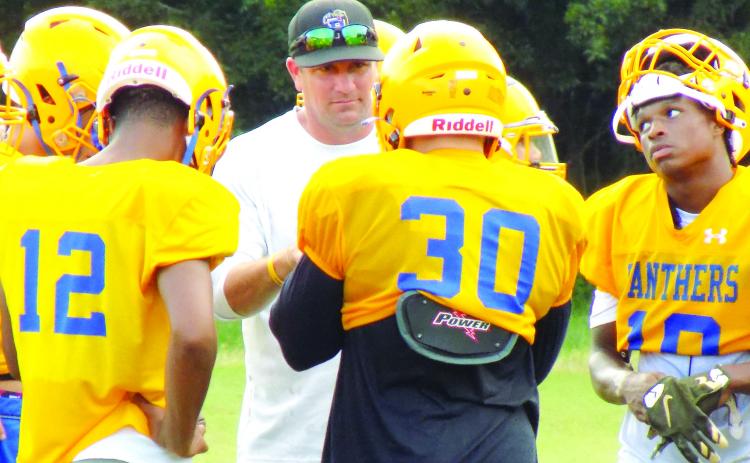 New Palatka High School football coach Patrick Turner goes over plays with his offense during a recent practice. (COREY DAVIS / Palatka Daily News)