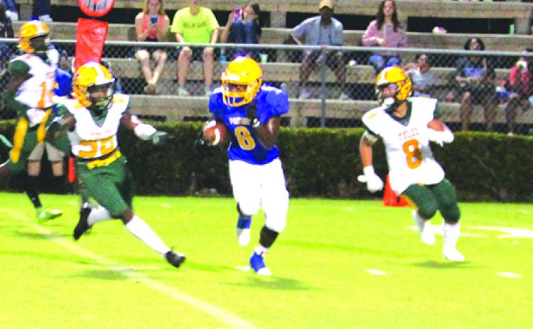 Palatka’s Q’Juan Nelson finds a hole between Yulee defenders Braylen Ricks (left) and Ernest Cortez for a 91-yard touchdown kickoff return to start the game Friday night. (MARK BLUMENTHAL / Palatka Daily News