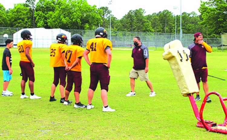 Crescent City Jr.-Sr. High football coach Sean Delaney (middle) and assistant Tim Ross (right) oversee a Raiders practice. The Raiders open their season Friday night at Chiefland. (MARK BLUMENTHAL / Palatka Daily News)