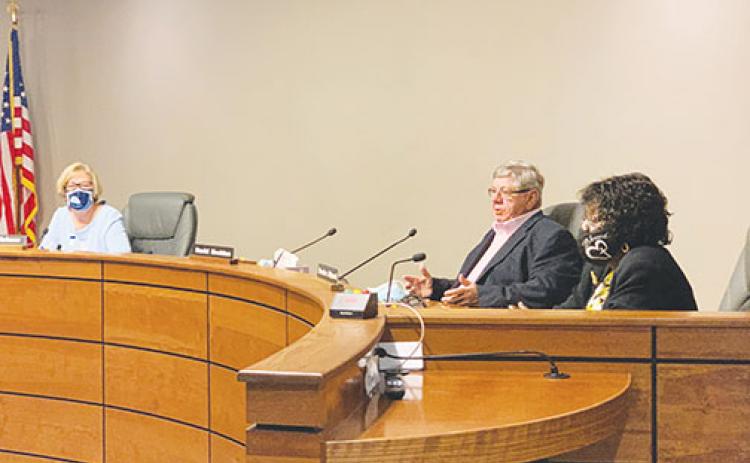 From left, school board members Holly Pickens, David Buckles and Sandra Gilyard participate in a meeting earlier this year.