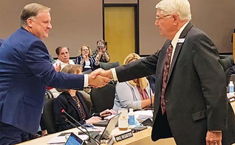 St. Johns River Water Management District Governing Board Chairman Douglas Burnett, right, congratulates Mike Register after Register was appointed as the district’s new executive director Tuesday. 