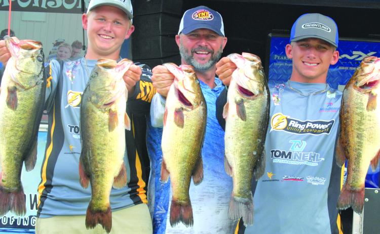 Holding up their winning fish are Parker Stalvey, emcee Glenn Cole and Jason Deel during this past weekend’s Florida B.A.S.S. Nation Junior/High School Fishing event. (GREG WALKER / Daily News correspondent)