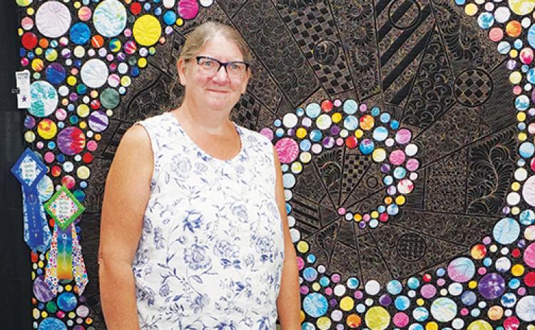 Bonnie Quinn of Palm Coast stands in front of her prize-wining quilt “Follow the Polka Dot Road” at Miss D’s Quilts By the River juried show and exhibition in Palatka.