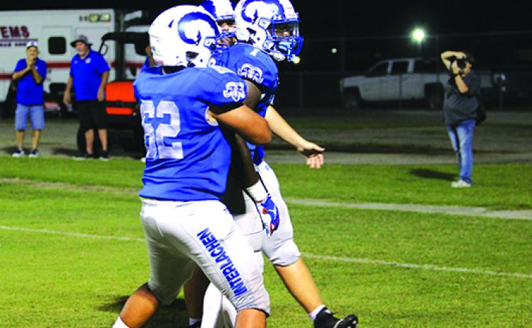 Interlachen quarterback Reggie Allen Jr. (middle) celebrates a second-quarter touchdown with Nathan Jenkins (62) and an unidentified teammate Friday night in a 27-6 victory over Bell. (MARK BLUMENTHAL / Palatka Daily News)