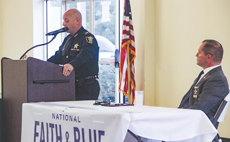 As Sheriff Gator DeLoach looks on, Putnam County Sheriff’s Office Col. Joe Wells speaks to religious leaders last week about body cameras coming to the agency.