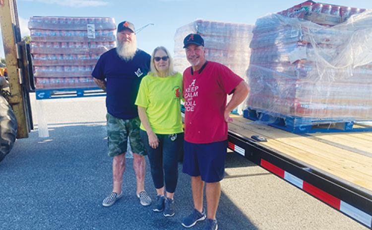 Feed the Need of Putnam County officials Randy Bolen and Denise Bramlitt and retired Jif employee Bill Curtis stand in front of the shipment of peanut butter the company donated to the local nonprofit.