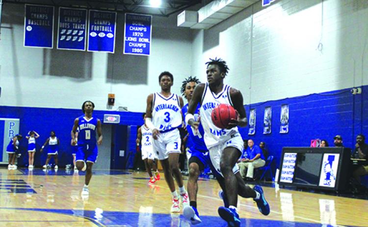 Interlachen’s Chris Johnson heads to the basket pursued by Belleview’s Cori Johnson with Johnson’s teammate, Jaden Perry (3), behind both during Monday’s opening game for both teams. (MARK BLUMENTHAL / Palatka Daily News)