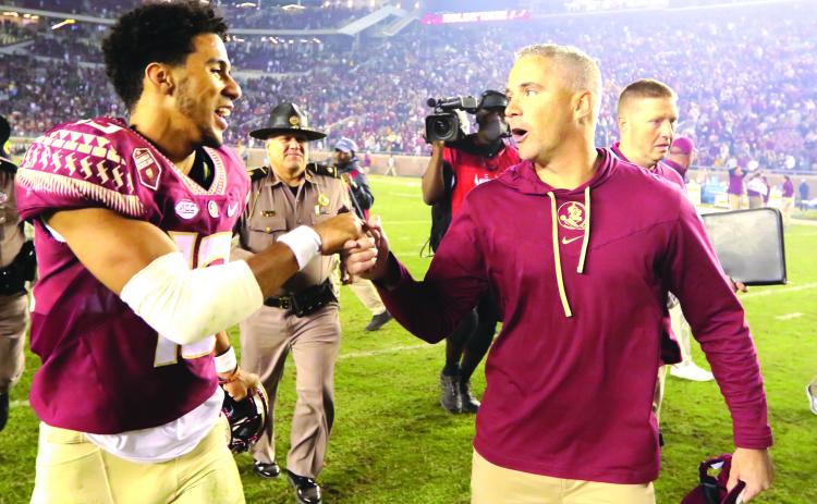 Florida State quarterback Jordan Travis gets congratulations from head coach Mike Norvell after the Seminoles defeated Miami, 31-28, on Saturday. (GREG OYSTER / Special to the Daily News)