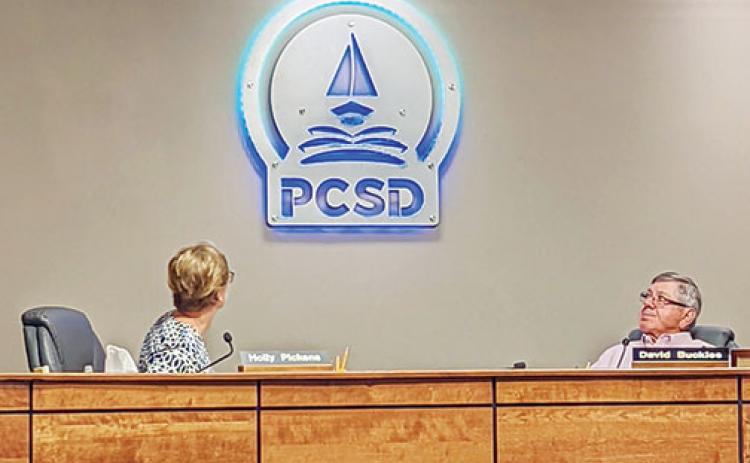 Putnam County School District board members Holly Pickens and David Buckles regard the mounted, lit version of the district’s new logo in the board’s meeting room during a meeting Tuesday afternoon.