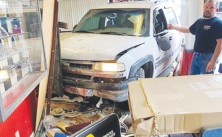 Eugene Wilkinson stands beside a vehicle that crashed into his auto repair shop, Eugene & Sons Tire & Auto, early Monday morning. According to Wilkinson’s wife and co-owner, Leota Wilkinson, a woman crashed her vehicle into the shop after suffering a medical episode while driving but no one was severely injured in the crash.