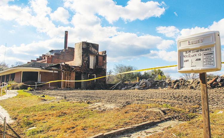 A sign marks the continuation of a project to revamp the former Florida Furniture building that was consumed by fire Dec. 19.