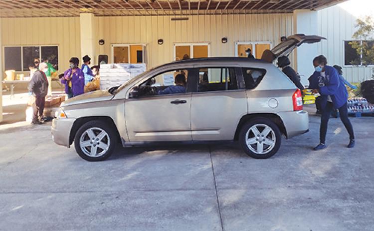A volunteer loads food into a vehicle at the Family Life Center.