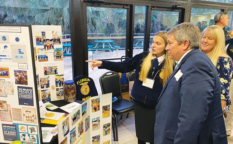 A Future Farmers of America student shows Superintendent Rick Surrency some of the program’s highlights.