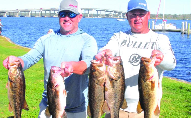 Jason Caldwell and Lee Stalvey hold up their winning creel in the recent Messer’s Bait & Tackle Invitational bass tournament. (GREG WALKER / Daily News correspondent)