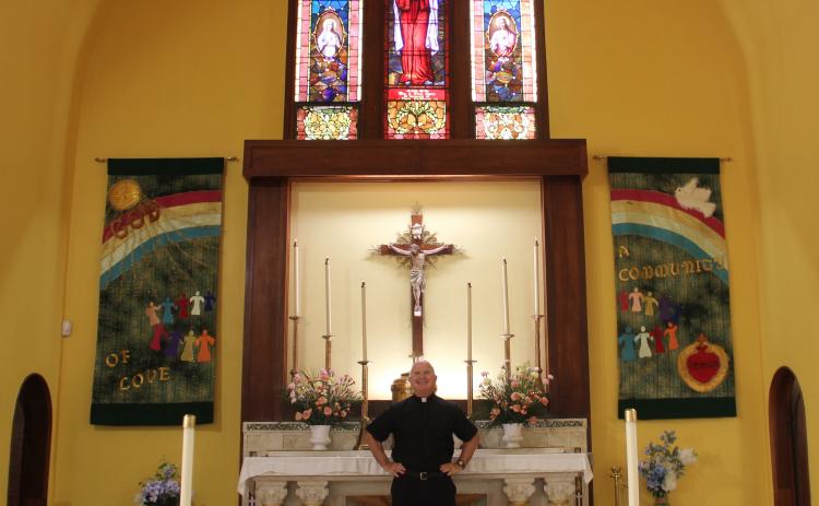 Father Camarda stands at the head of St. Monica's Catholic Church for one of the last times.