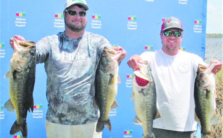 Will Scaife, left, and Branden Waters hold up some of the 30.66 pounds of bass they reeled in to win last year’s Wolfson Children’s Hospital Bass Tournament. The pair will be back to defend their championship on Saturday. (Daily News file photo)