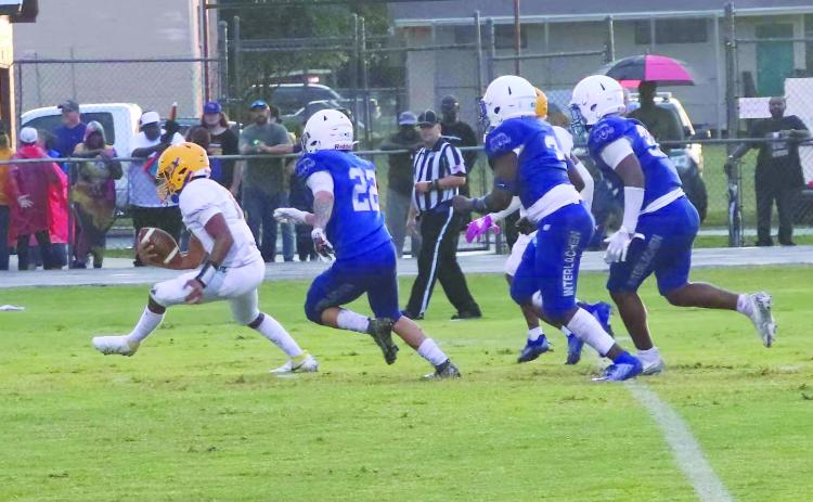 Palatka quarterback Jamarrie McKinnon tries to escape trouble with Interlachen defenders pursuing, the closest being Jonathan Servin (22). (RITA FULLERTON / Special to the Daily News)
