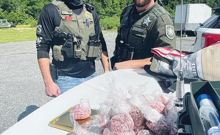 Deputies pose with roughly 10,000 doses of seized ecstasy pills Tuesday afternoon.