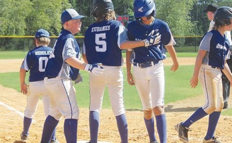 Melrose teammates Hunter Thomas and Gavin Eubanks congratulate Ryder Trull after Trull’s sixth-inning solo home run Sunday against The Villages Bombers. (MARK BLUMENTHAL/Palatka Daily News
