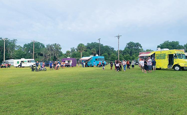 A crowd of people lines up to grab a bite to eat from food trucks during one of Welaka’s Food Truck Friday events earlier this year.