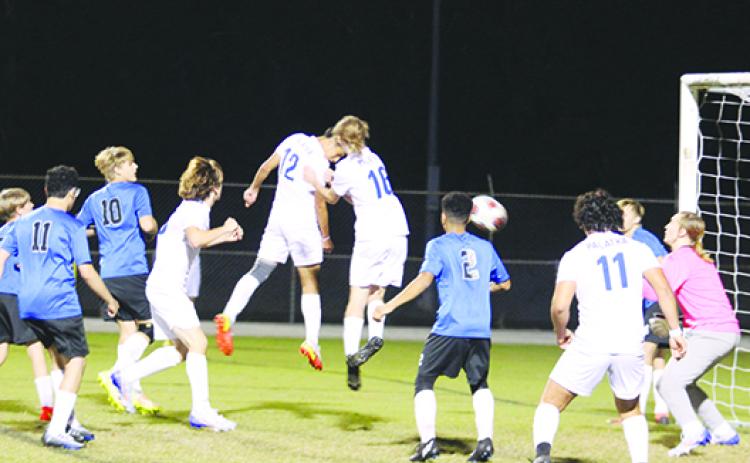 Palatka’s Isahu Aboytes (12) jumps with teammate Ashton Kenyan and heads the ball in past Interlachen goalie Landon McCollum to make it 3-1 in the first half of Monday night’s game at Feltner Field at Thompson-Baker Stadium. (MARK BLUMENTHAL / Palatka Daily News)