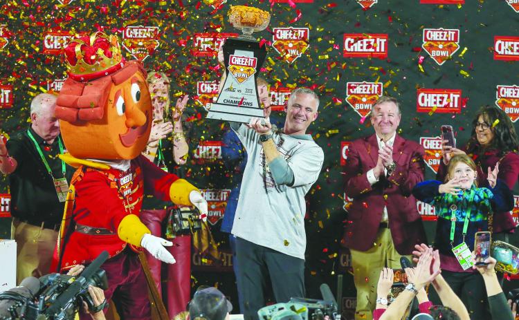 Florida State football coach Mike Norvell hoists the trophy after his Seminoles beat Oklahoma, 35-32, in last week’s Cheez-It Bowl. (GREG OYSTER / Special to the Daily News)