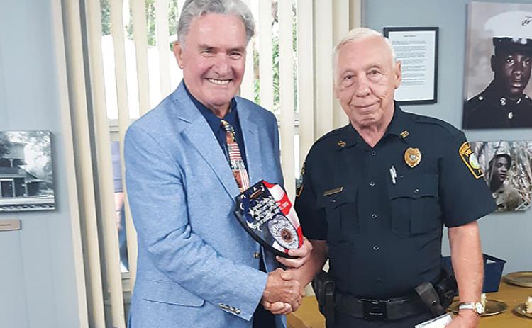 Interlachen Mayor Ken Larsen, left, honors Interlachen Police Department Chief Larry Wilburn last week for his 40-year career with the town’s law enforcement agency.