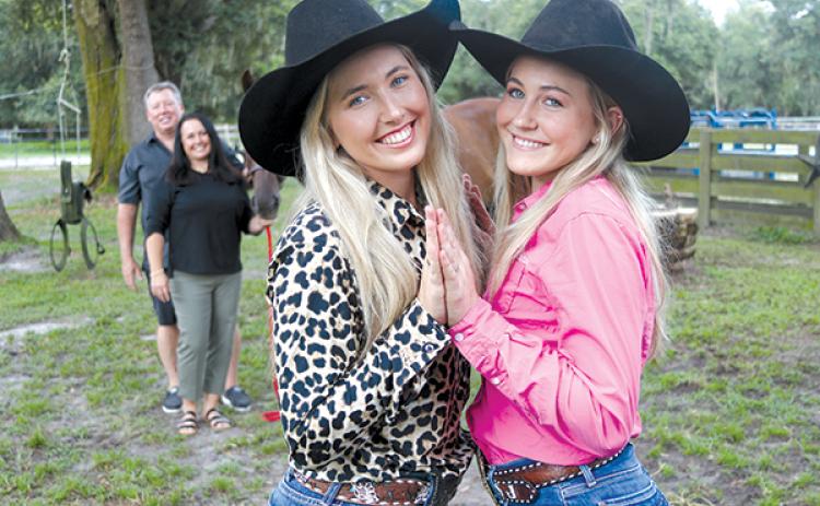 TRISHA MURPHY/Palatka Daily News -- Shaeley Jenkins, 19, left, and her younger sister, Shanley, 14, stand in the foreground as their parents, John and Becky Jenkins, stand with their horse. 