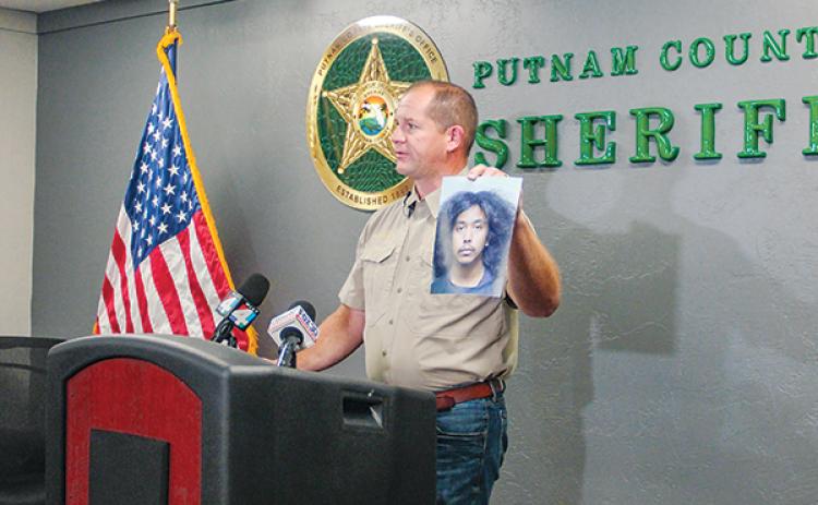 SARAH CAVACINI/Palatka Daily News – Putnam County Sheriff Gator DeLoach holds up a photo of Mathew Daniel Temael, 22, Monday who was charged with homicide for the March death of Hawthorne resident Louis Stackhouse.