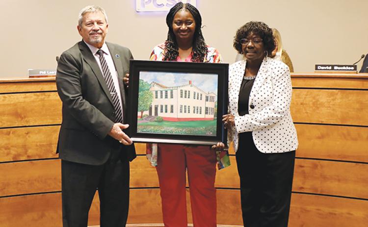 Photo submitted by Felicia Cahan – From left to right, Superintendent Rick Surrency, Gloria Lee and school board Chairwoman Sandra Gilyard hold a portrait of Central Academy that Lee’s husband painted. 