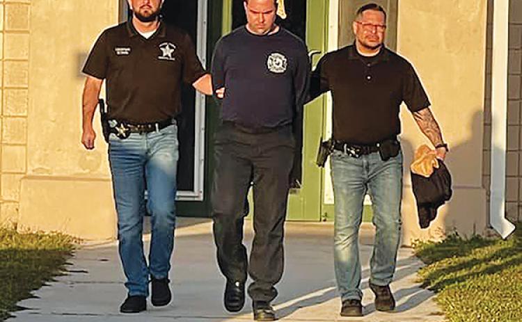 Photo courtesy of the Putnam County Sheriff's Office – Investigators from the Putnam County Sheriff's Office walk Sean Carpenter, 36, to be booked on charges of lewd and lascivious conduct on a child.
