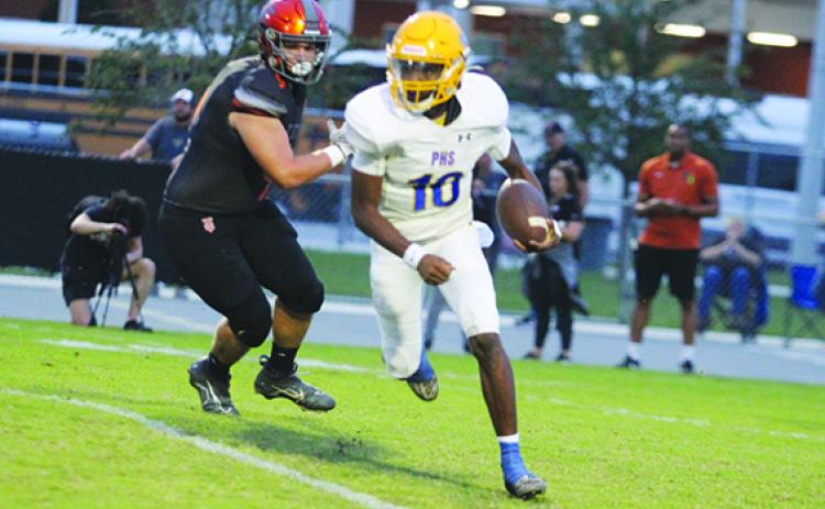 Palatka quarterback Tommy Offord eludes the tackle attempt by Tocoi Creek’s Carson Collins during Friday night’s Tocoi Creek victory. (MARK BLUMENTHAL / Palatka Daily News)