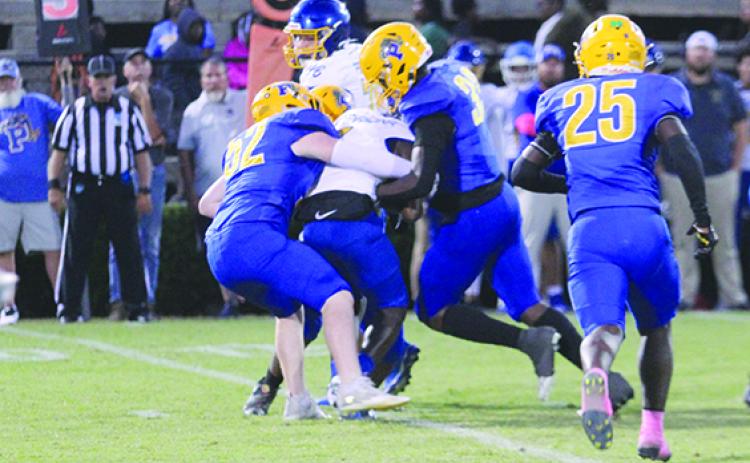 Palatka’s Kason Bradford (52) and Elysha Campbell II hold up Fernandina Beach running back D’ante Simms for a small gain Friday night, while teammate Tarus Session rushes in late. (MARK BLUMENTHAL / Palatka Daily News)