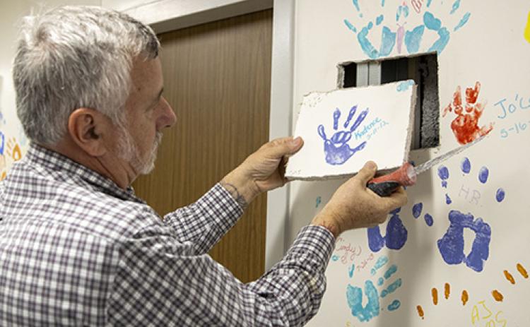 Submitted by David Chudzik. Wayne Placona, HCA Florida Putnam's director of facilities services, cuts out Kadance Branam's handprint to save for her family. 