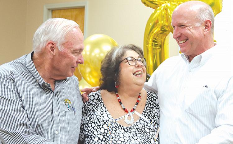 TRISHA MURPHY/Palatka Daily News – Beck Automotive Group leaders Wayne McClain, left, and Breck Sloan, right, congratulate Jo Downs for reaching her 40th anniversary with the company.