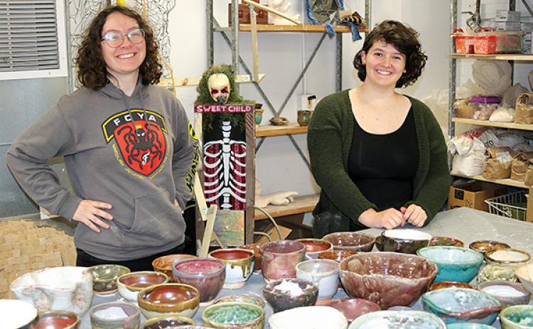 TRISHA MURPHY/Palatka Daily News - Florida School of the Arts students Carol Stephenson, left, and Brynn Lacouture hold the bowls they made that will be used in the Empty Bowls fundraiser next week.