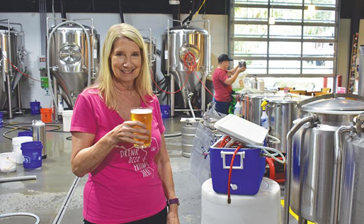 BRANDON D. OLIVER/Palatka Daily News – Azalea City Brewing Co. owner Andrea Conover holds a beer in her taproom during the business' third-anniversary celebration.