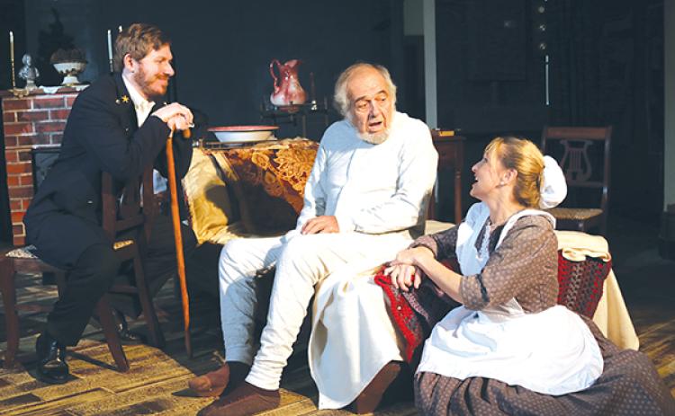 TRISHA MURPHY/Palatka Daily News In a scene from River City Player’s upcoming show, “Ebenezer,” Timothy Cratchit, left, played by Christopher Doody, and nurse Alice Poole, right, played by VaRonica Spangler, give Ebenezer Scrooge, played by Mike Pivko, an invitation to become one of the spirits.