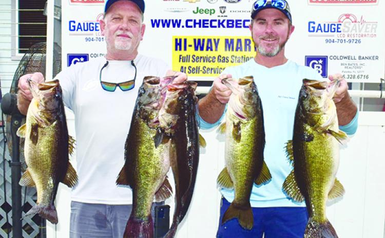 Brett Bollinger (left) and Justin Atkinson hold up their winning creel from the Putnam Paws Open Benefit Bass Tournament. (GREG WALKER / Daily News correspondent)