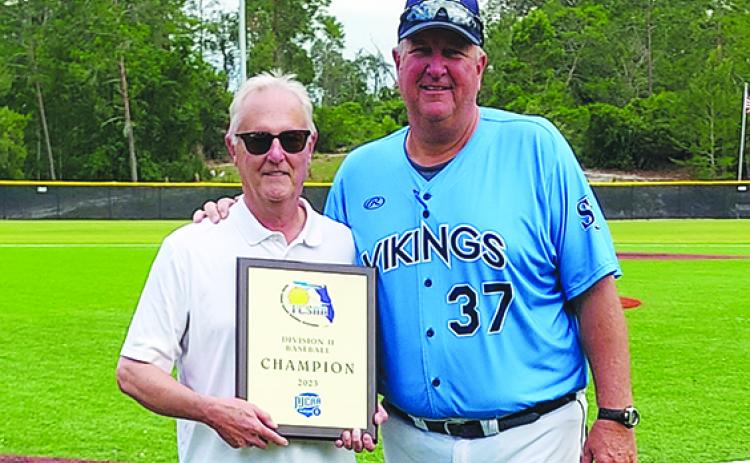 St. Johns River State College President Joe Pickens and baseball coach and athletic director Ross Jones pose with the Region 8 championship the Vikings won last May. (Submitted / St. Johns River State College)