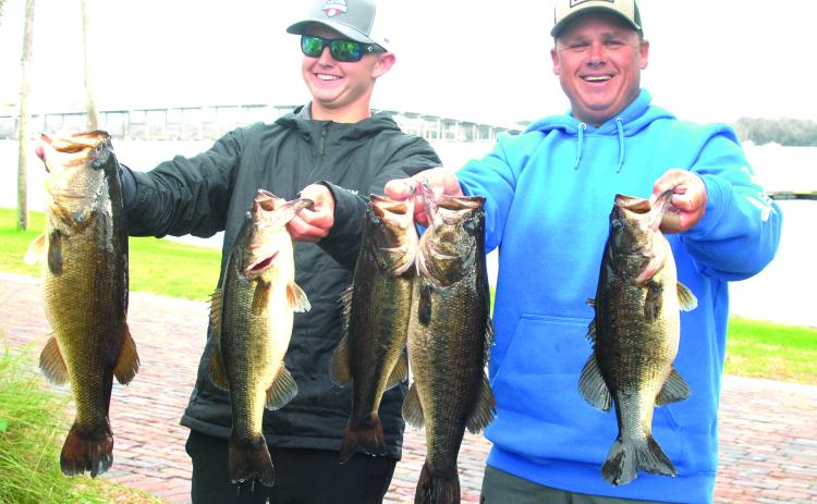 Son Parker (left) and father Lee Stalvey hold up their winning fish at Palatka City Dock during the Jan. 13 competition. (GREG WALKER / Daily News correspondent)