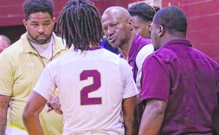 Crescent City Junior-Senior High School boys basketball coach Al Carter (right) talks with Eric Jenkins Jr. during a timeout of a game in December. The Raiders moved on to tonight’s District 4-3A semifinal matchup after defeating Sanford Crooms Academy, 55-45, Monday night. (RITA FULLERTON / Special to the Daily News)