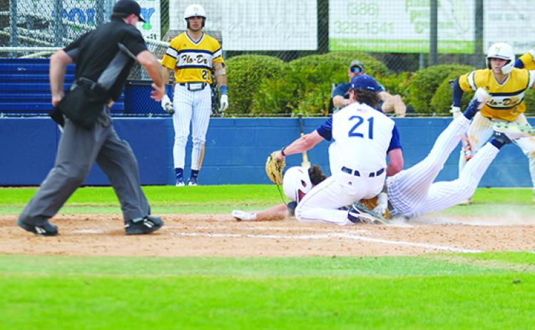 Florence-Darlington’s Devin Mitchell slides safely into home plate ahead of the tag attempt of St. Johns River State College pitcher Caden Kok (21) to give his team a 5-4 lead in the sixth inning on Friday in the John Tindall Classic at Tindall Field. (MARK BLUMENTHAL / Palatka Daily News)