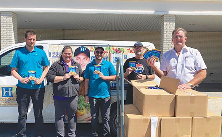 Photo submitted by Larry Havey – County Commissioner Larry Harvey, right, stands with employees of Hitchcock’s Market in Interlachen on Monday after purchasing more than 2,000 tuna packets to donate to Feed the Need of Putnam County.
