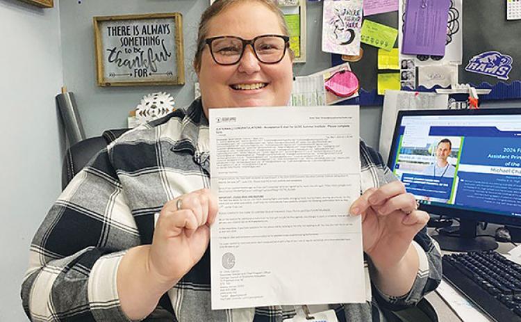 Photo courtesy of Interlachen Junior-Senior High School – Katie Hess, an economics teacher at Interlachen Junior-Senior High School, holds the letter informing her she has been accepted to attend a conference in Georgia this summer.