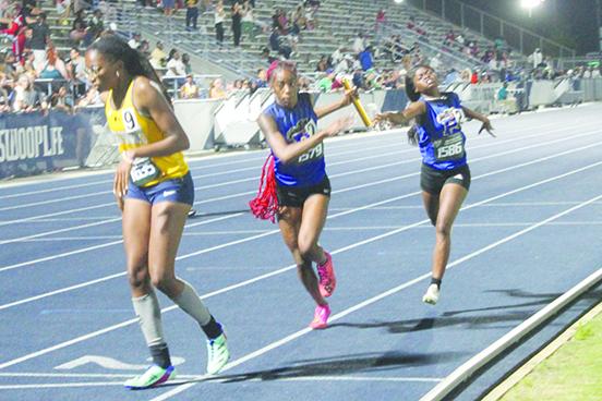 Palatka’s Ymira Passmore (right) hands the baton off to teammate Jahzara Fields on the final leg of the 4x400 relay during Thursay night’s FHSAA 2A championship. (MARK BLUMENTHAL / Palatka Daily News)