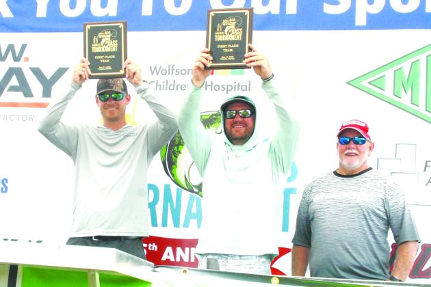 Tyler DeRuiter and Thomas Grizz Boney hold up their championship trophies in the Wolfson Children’s Hospital VIP & Friends Bass Tournament on Friday. (GREG WALKER / Correspondent)